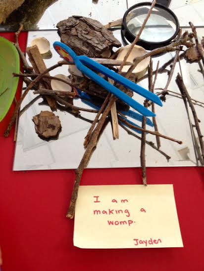 Blue clothespins clipped to sticks, with a note saying 'I am making words.'